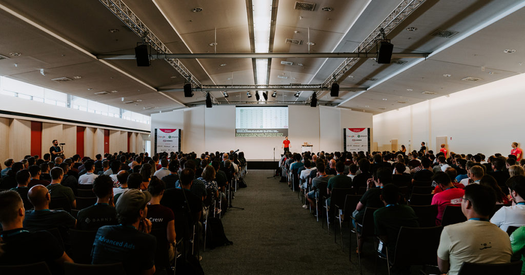 WordCamp photo with a speaker on stage and a full audience